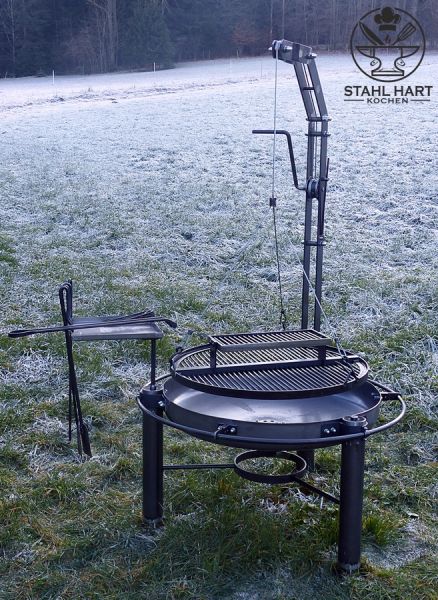Großer Schwenkgrill auf grüner Wiese im Freien