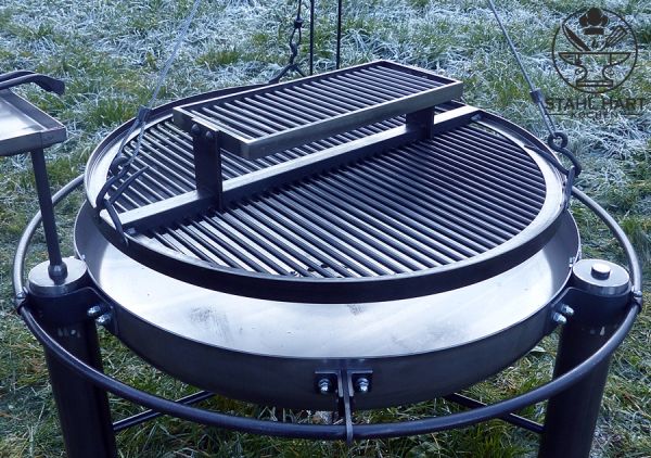Großer Schwenkgrill auf grüner Wiese im Freien
