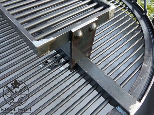 Großer Schwenkgrill auf grüner Wiese im Freien