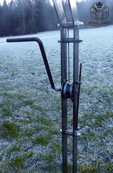 Großer Schwenkgrill auf grüner Wiese im Freien